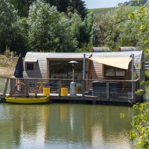 Cabane flottante en Bourgogne, avec terrasse sur leau et vue verdoyante.