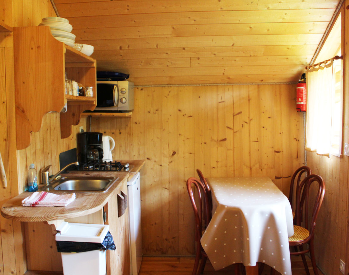 Cabane en bois en Bourgogne-Franche-Comté, avec cuisine équipée et table à manger.