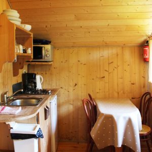 Cabane en bois en Bourgogne-Franche-Comté, avec cuisine équipée et table à manger.