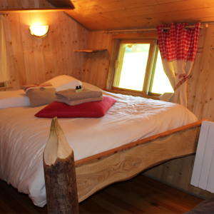 Chalet en bois avec lit douillet et vue sur la nature en Bourgogne-Franche-Comté.