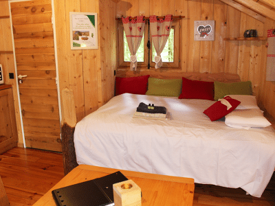 Chalet en bois chaleureux avec lit douillet et décor coloré à Bourgogne-Franche-Comté.