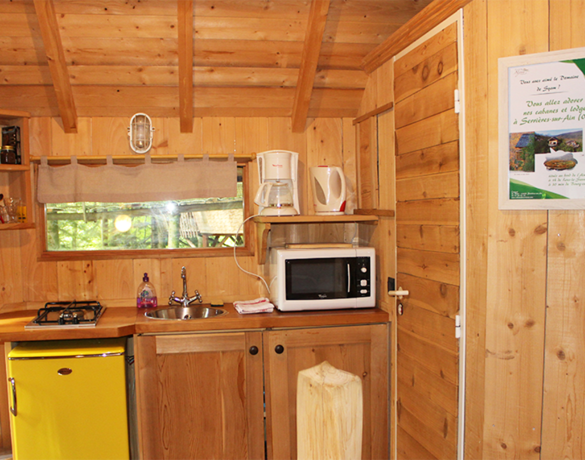 Cabane en bois à Bourgogne-Franche-Comté, cuisine équipée et ambiance chaleureuse.
