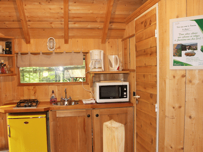 Cabane en bois à Bourgogne-Franche-Comté, cuisine équipée et ambiance chaleureuse.