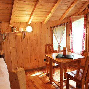 Cabane en bois cosy avec table en bois et lumière naturelle à Bourgogne-Franche-Comté.
