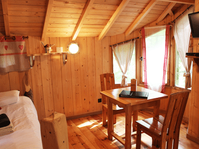 Cabane en bois cosy avec table en bois et lumière naturelle à Bourgogne-Franche-Comté.