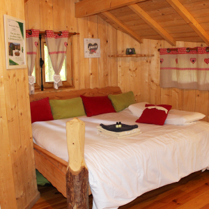Chalet en bois chaleureux avec lit douillet et décor coloré à Bourgogne-Franche-Comté.