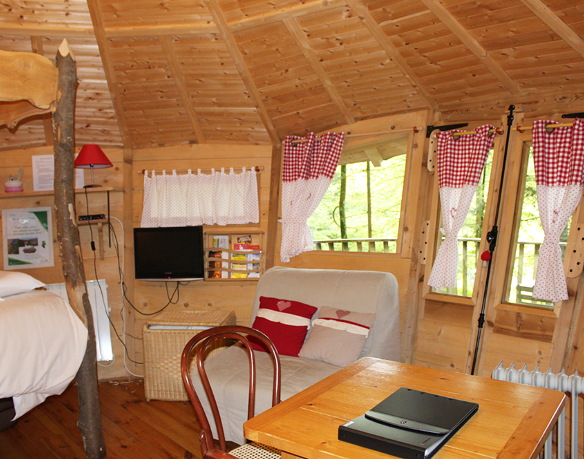 Cabane en bois cosy avec fenêtres à carreaux et décoration chaleureuse.