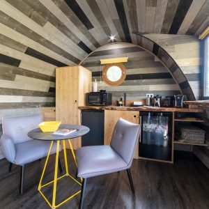 Hébergement insolite en Bourgogne : intérieur moderne avec murs en bois et coin salon cosy.