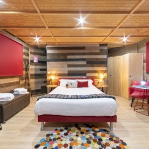 Chambre moderne en bois avec lit confortable et réfrigérateur rétro à Bourgogne.