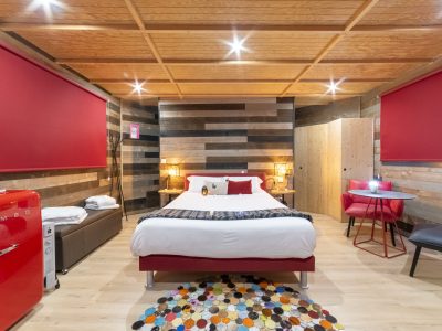 Chambre moderne en bois avec lit confortable et réfrigérateur rétro à Bourgogne.