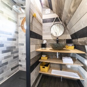 Douche moderne en bois dans un hébergement insolite en Bourgogne. Ambiance chaleureuse.