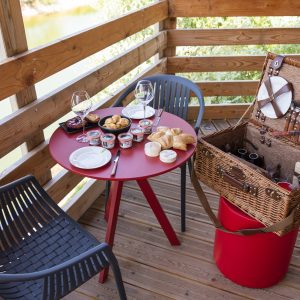 Hébergement insolite en Bourgogne : terrasse avec vue, panier pique-nique et table rouge.
