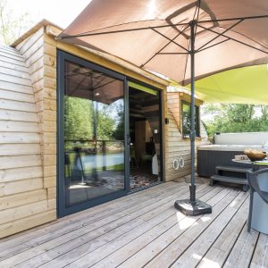 Hébergement insolite en Bourgogne : cabane en bois avec terrasse et jacuzzi.