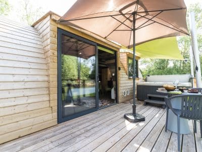 Hébergement insolite en Bourgogne : cabane en bois avec terrasse et jacuzzi.