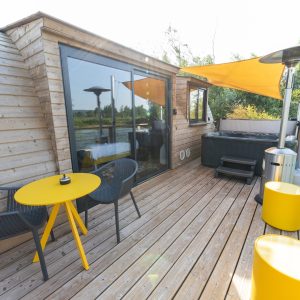 Hébergement insolite en Bourgogne : cabane sur leau avec terrasse en bois et jacuzzi.