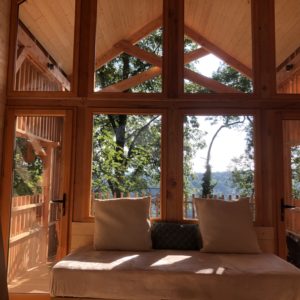 Cabane en bois avec grandes fenêtres, offrant une vue imprenable sur la nature.