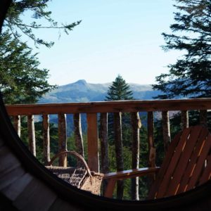 Cabane perchée en Auvergne avec vue panoramique sur les montagnes environnantes.