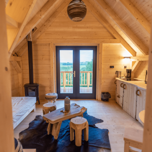 Cabane en bois avec vue dégagée, intérieur chaleureux et décor naturel.