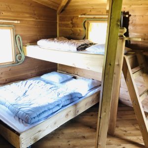 Cabane en bois avec lits superposés et ambiance chaleureuse en Auvergne-Rhône-Alpes.