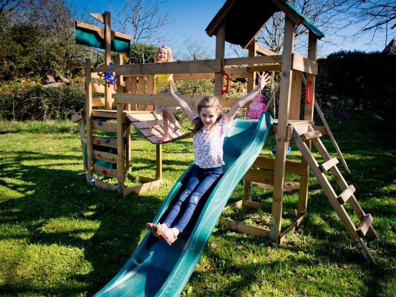 Aire de jeux en bois avec toboggan, idéale pour les familles en vacances.