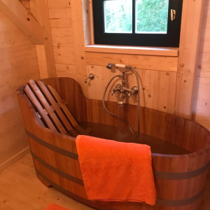 Hébergement insolite en Midi-Pyrénées avec baignoire en bois et ambiance chaleureuse.