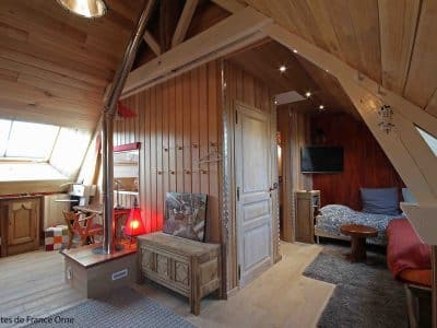 Chalet en bois à Basse-Normandie, intérieur chaleureux avec poutres apparentes.