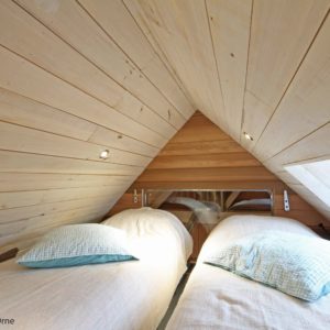 Chambre en bois dans un hébergement insolite en Basse-Normandie, ambiance cosy.
