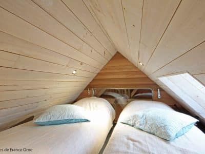 Chambre en bois dans un hébergement insolite en Basse-Normandie, ambiance cosy.
