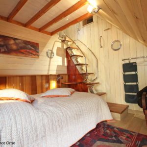 Chalet en bois cosy avec lit douillet et décoration chaleureuse à Basse-Normandie.