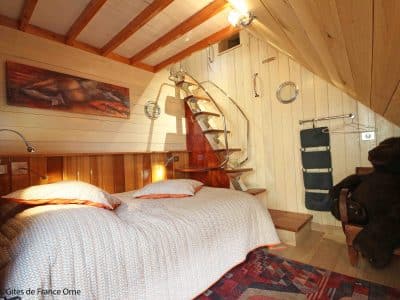 Chalet en bois cosy avec lit douillet et décoration chaleureuse à Basse-Normandie.