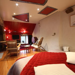 Hébergement insolite en Basse-Normandie, chambre avec murs en pierre et décor moderne.