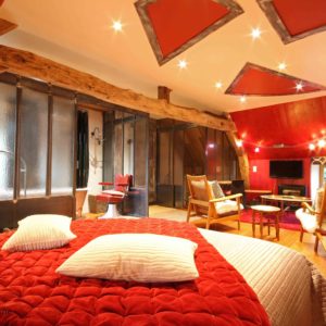 Hébergement insolite en Basse-Normandie, chambre avec un plafond original et des poutres en bois.