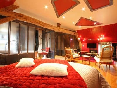 Hébergement insolite en Basse-Normandie, chambre avec un plafond original et des poutres en bois.