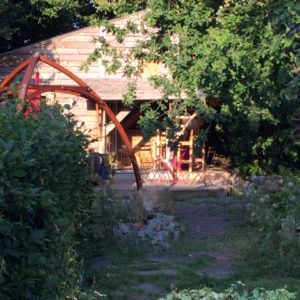 Cabane en bois à Basse-Normandie, entourée de verdure et avec une terrasse accueillante.