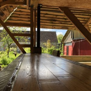 Hébergement insolite en Basse-Normandie, avec un bar en bois et vue sur le jardin verdoyant.