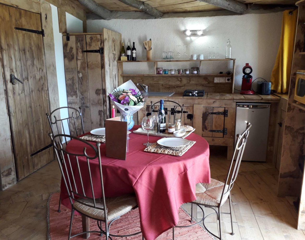 Hébergement insolite en Languedoc-Roussillon, avec une cuisine en bois et une table ronde.