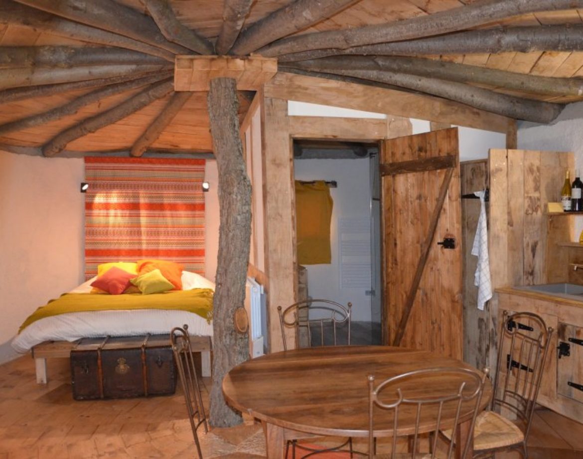 Cabane en bois avec un lit douillet et des éléments naturels, au cœur du Languedoc-Roussillon.