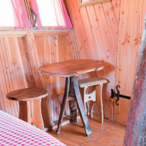 Hébergement insolite en Auvergne-Rhône-Alpes, intérieur en bois avec table rustique.