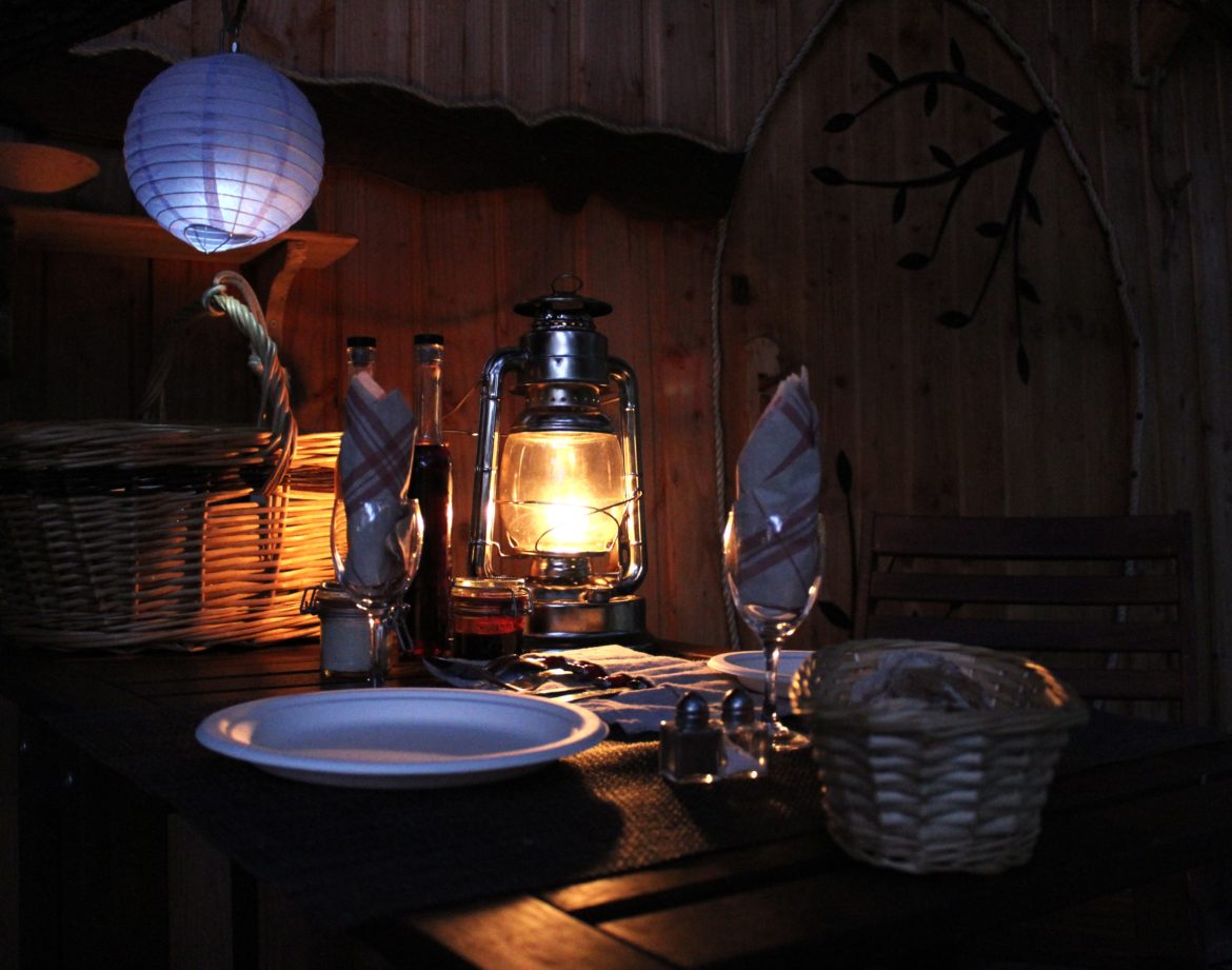 Hébergement insolite en Auvergne-Rhône-Alpes, table éclairée par une lanterne chaleureuse.