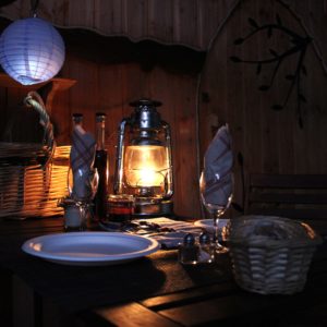 Hébergement insolite en Auvergne-Rhône-Alpes, table éclairée par une lanterne chaleureuse.