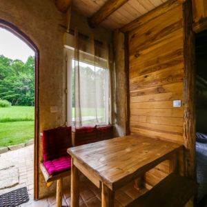 Hébergement insolite en bois avec vue sur la nature, table en bois et ambiance chaleureuse.