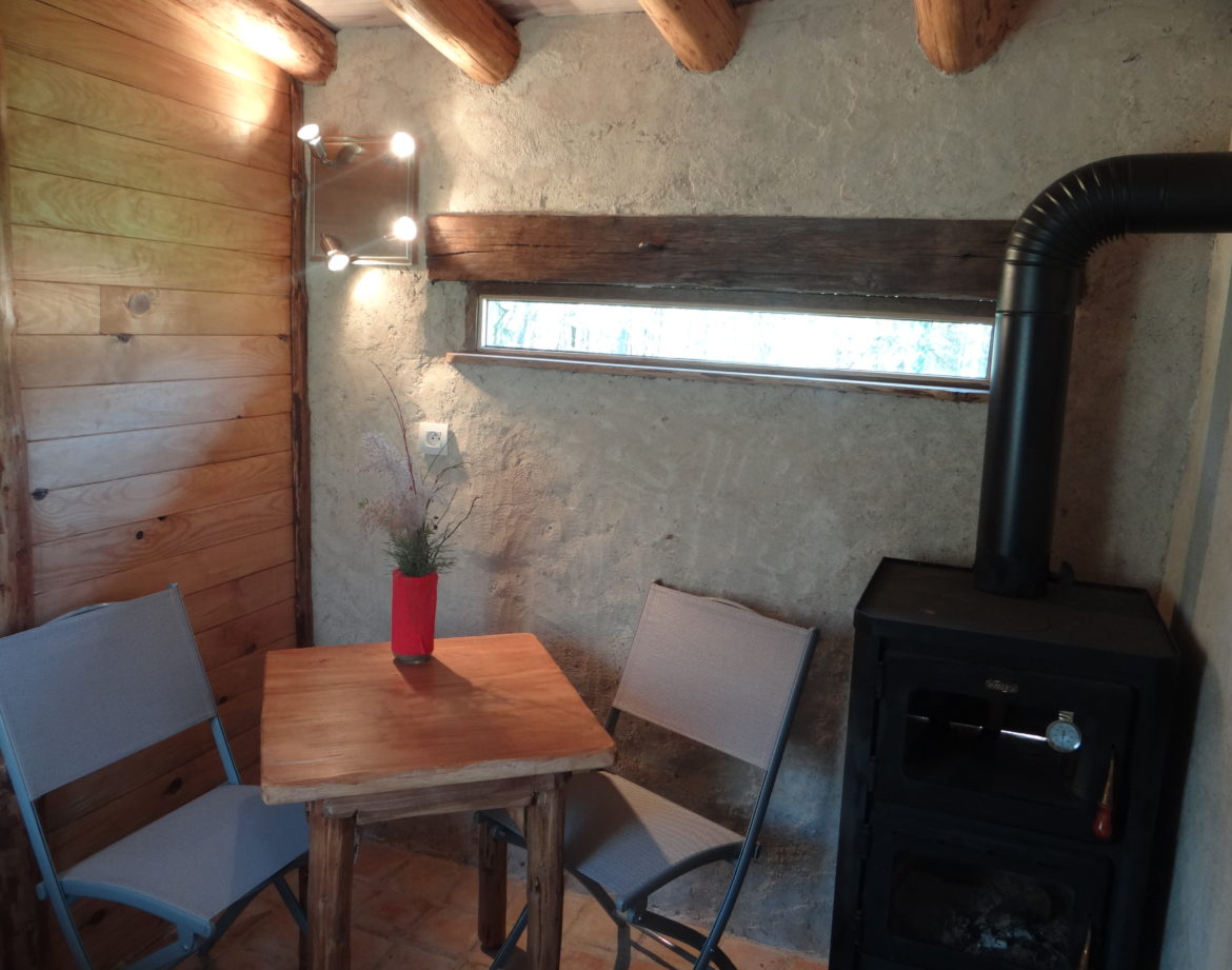 Hébergement insolite en bois dans le Grand-Est, avec poêle et coin repas cosy.