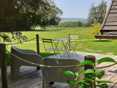 Hébergement insolite en Bourgogne : chalet avec terrasse et vue sur la verdure.