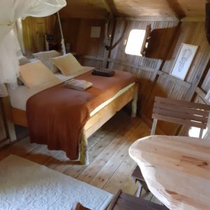 Cabane en bois cosy en Bourgogne, avec un lit douillet et une table en bois.