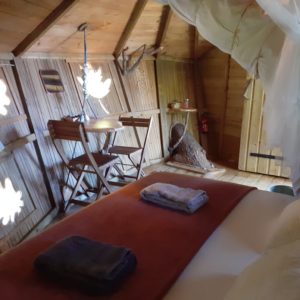 Cabane en bois à Bourgogne, avec lit douillet et décor naturel chaleureux.