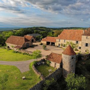 Hébergement insolite en Midi-Pyrénées : charmant château en pierre avec toits en tuiles.