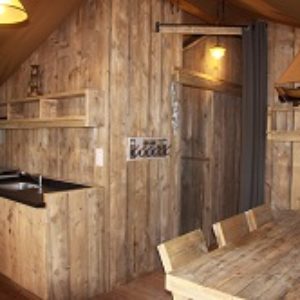 Cabane en bois avec cuisine équipée et décoration nautique chaleureuse.