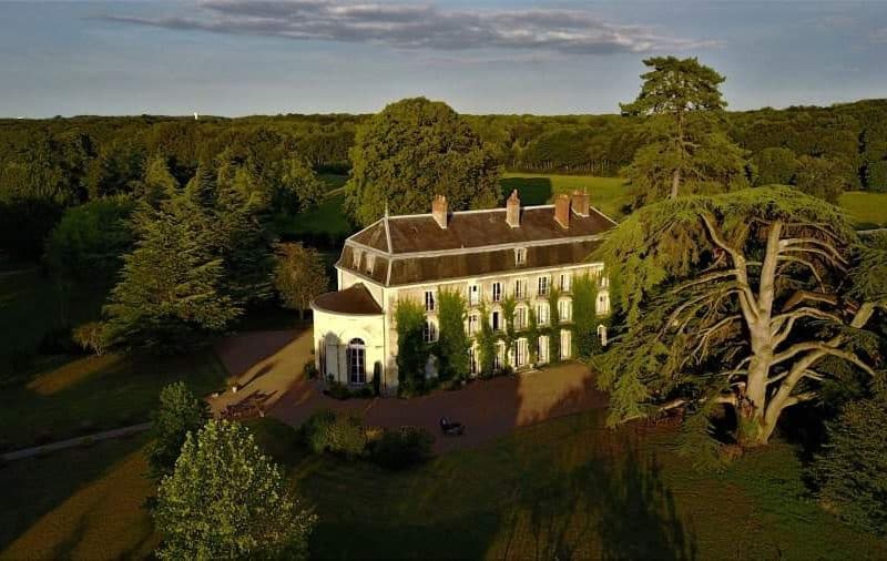 Château élégant entouré de verdure, idéal pour un séjour paisible en pleine nature.