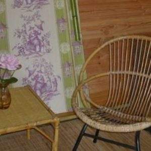 Hébergement insolite en Centre : intérieur en bois avec fauteuil en rotin et décoration vintage.