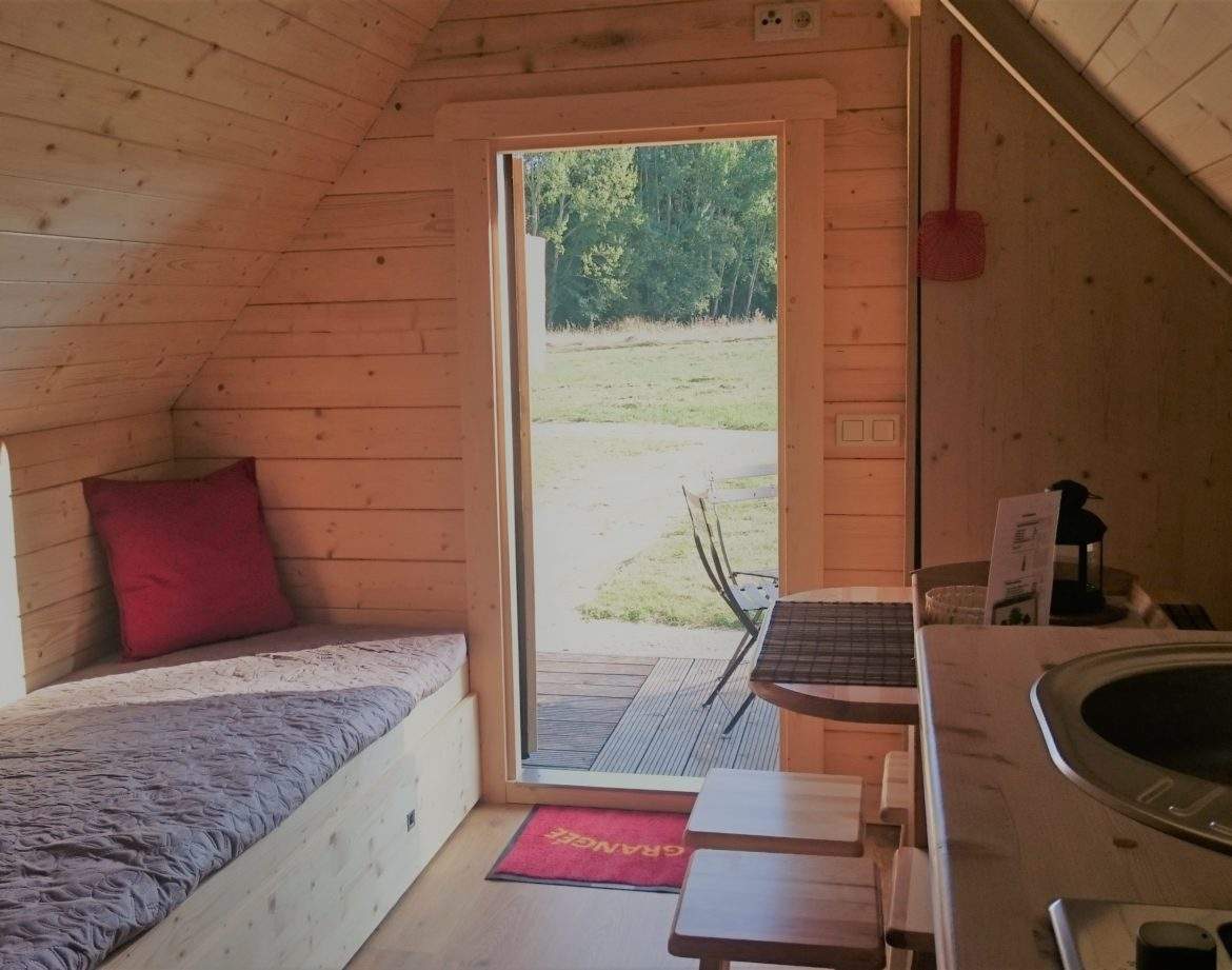 Cabane en bois cosy avec vue sur la nature et un coin repas lumineux.
